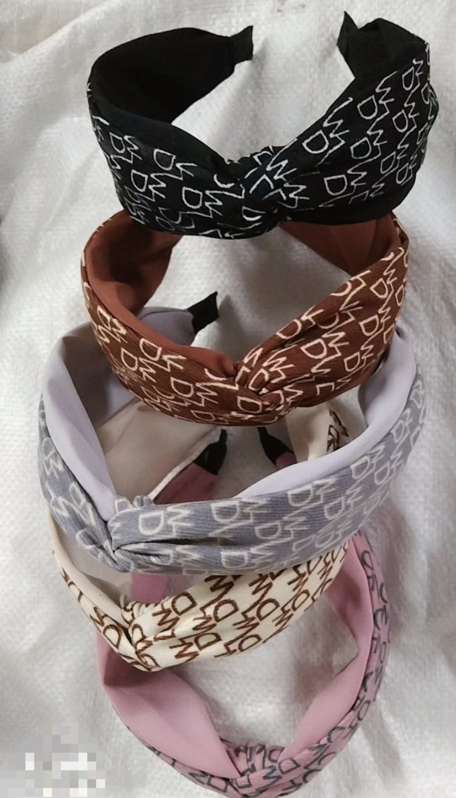 The autumn and winter collection features a brushed fabric DW letter two-color wide-edge hairband with a cross knot