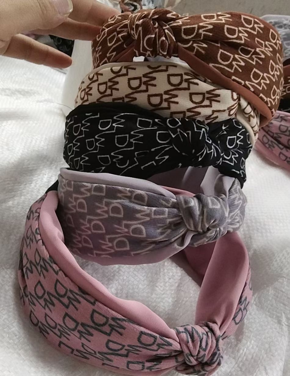 The autumn and winter collection features a brushed fabric DW letter two-color wide-edge hairband with a middle knot