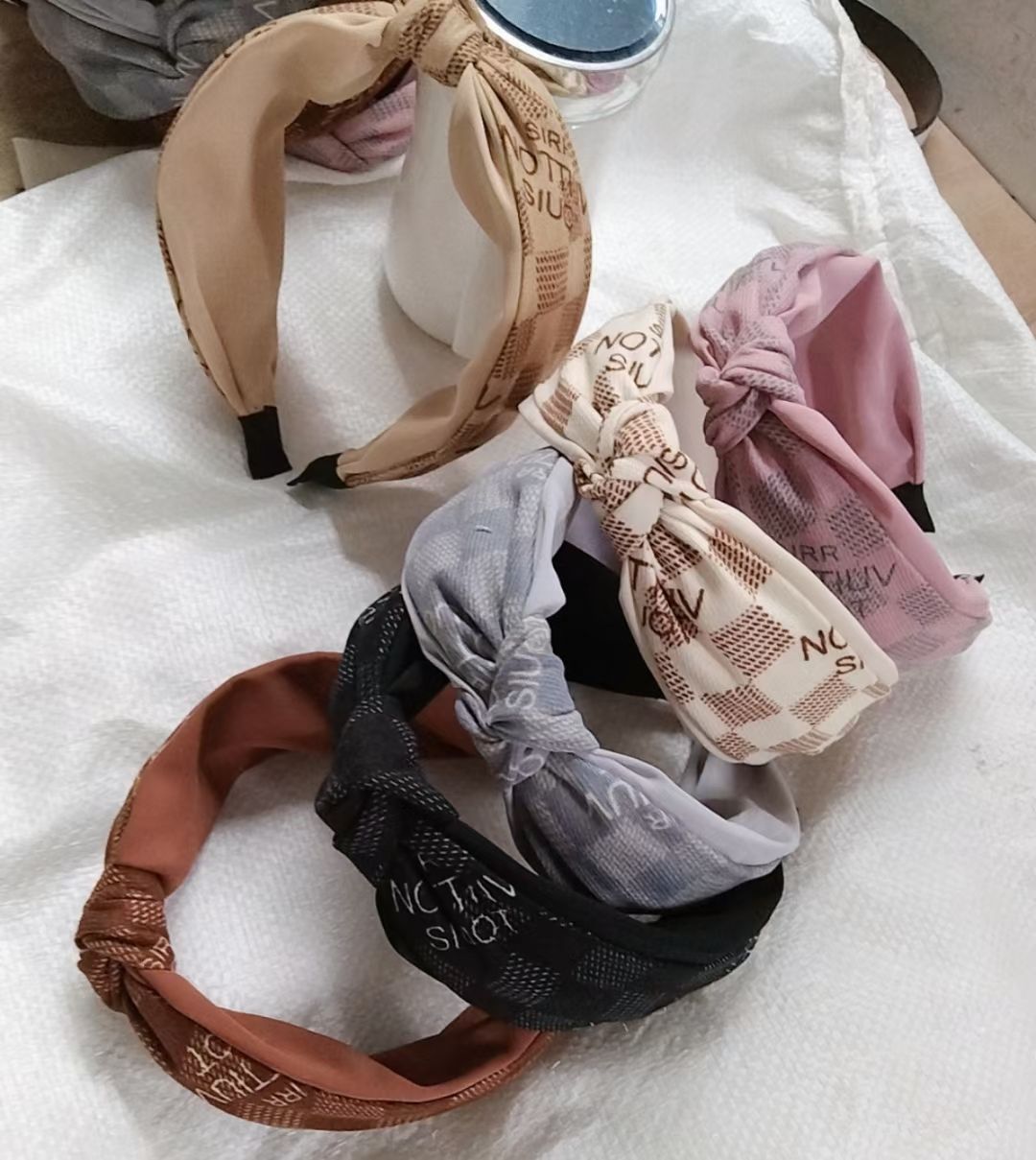 A fashionable and versatile two-color wide-brimmed hairband made of brushed fabric with a middle knot