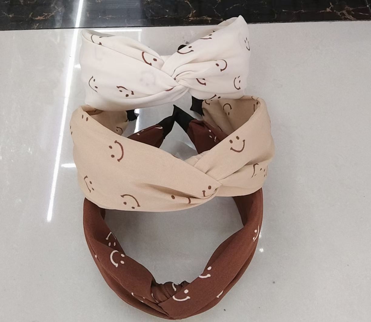 The Smiley Face milk tea series of fashionable fabric Korean style is versatile for going out. It features wide-edge hair bands with cross-tied hairbands for pressing hair and washing face
