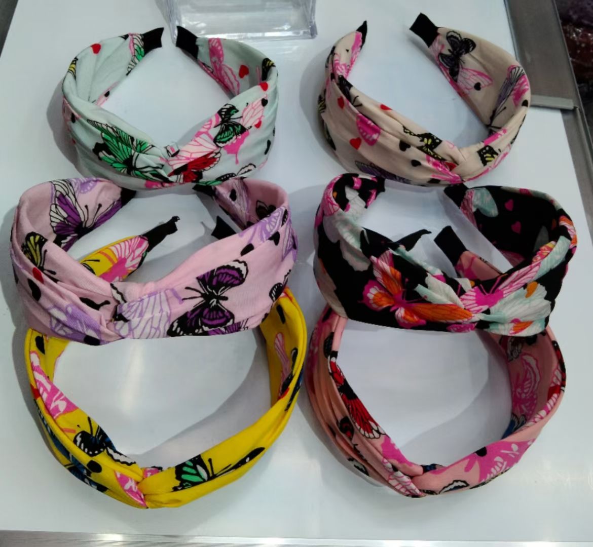 A simple and colorful bow style wide-brimmed hairband with a cross knot