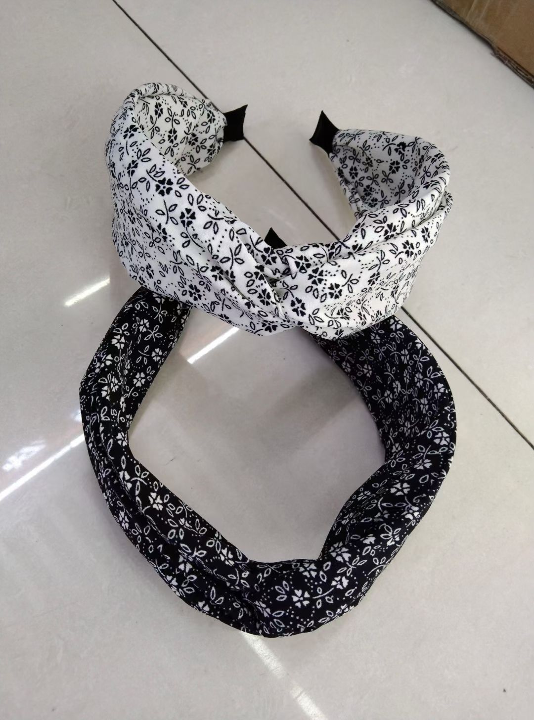 The Korean-style black and white series of small floral wide-brimmed hairbands are crossed and tied