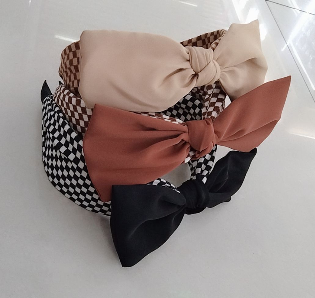 The cute girl's autumn and winter collection features a small checkered wide-brimmed hairband with a bow, looking like a fairy