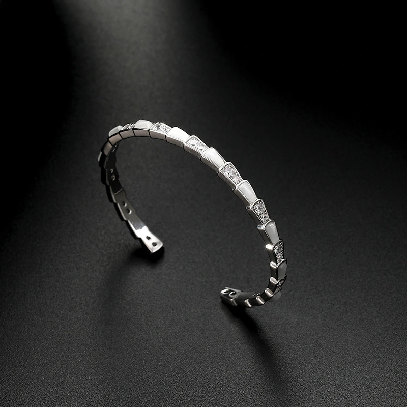 This is a trendy shell snake bone fashion bracelet with an open cat's eye detail image 2
