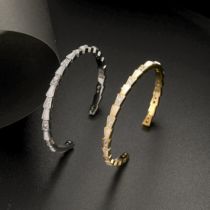 This is a trendy shell snake bone fashion bracelet with an open cat's eye detail image 1