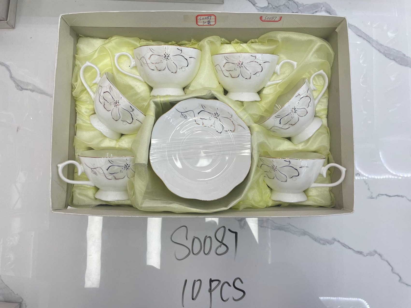 6 cups and 6 plates of white flowers
