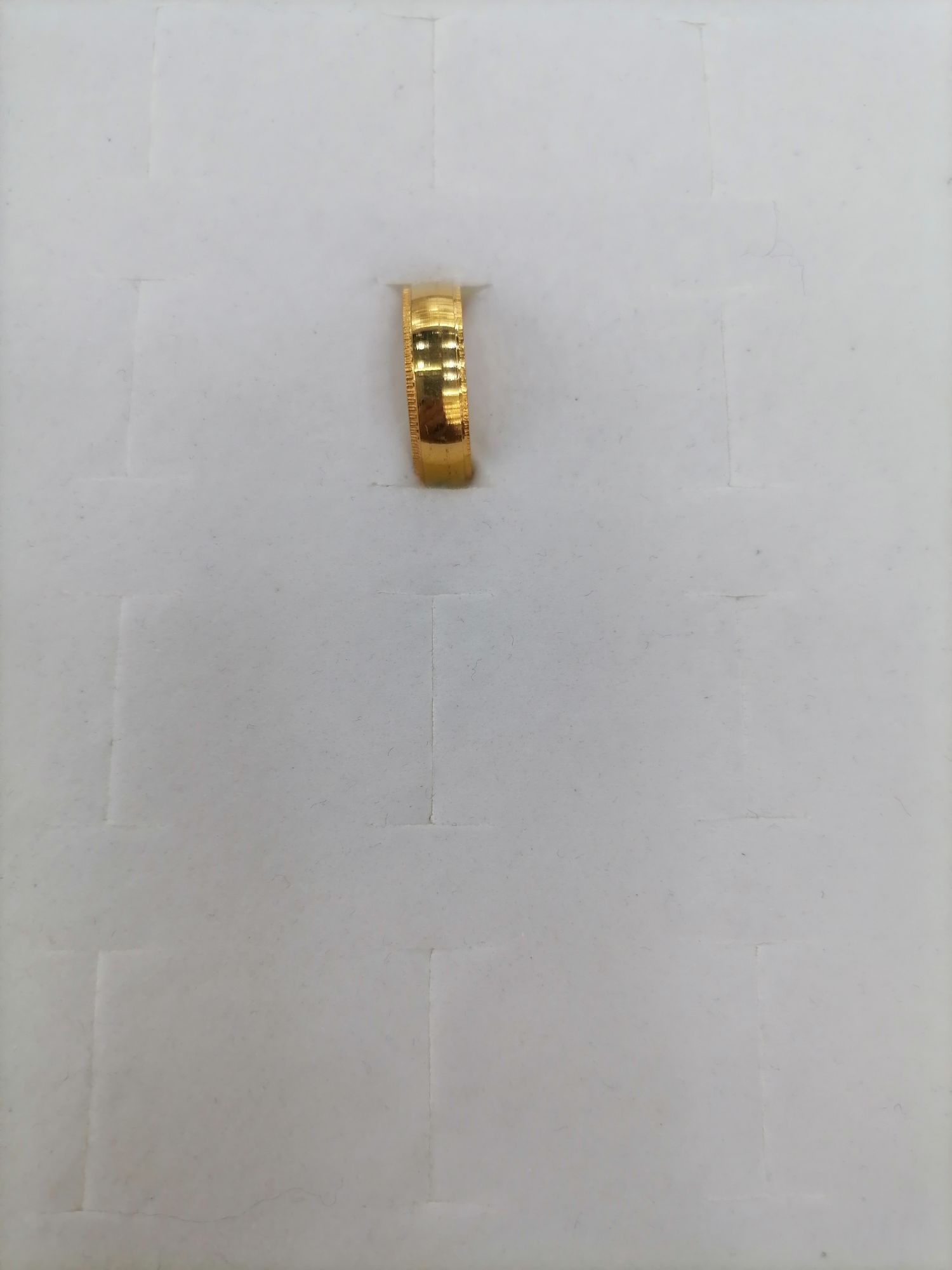 A titanium steel gold mid-wide ring with fine printed lines on the outside