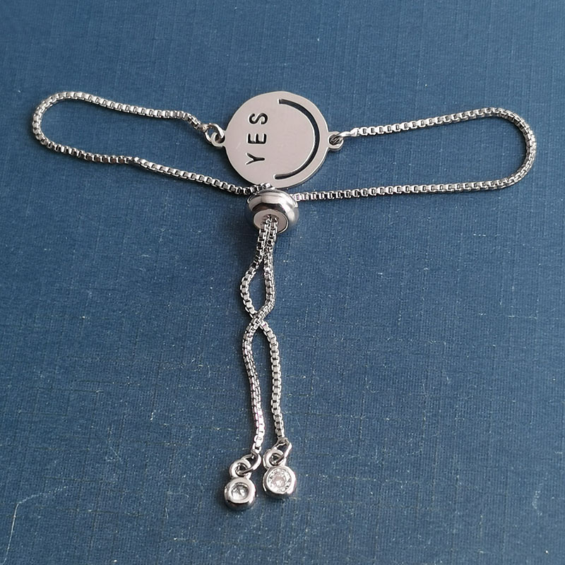 This is a popular and trendy titanium steel smiley yes bracelet pendant with a hip-hop punk expression for couples details Picture