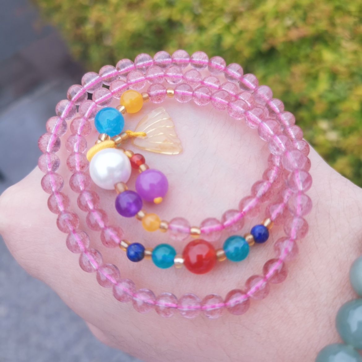 A woman wrapped a strawberry crystal bracelet three times