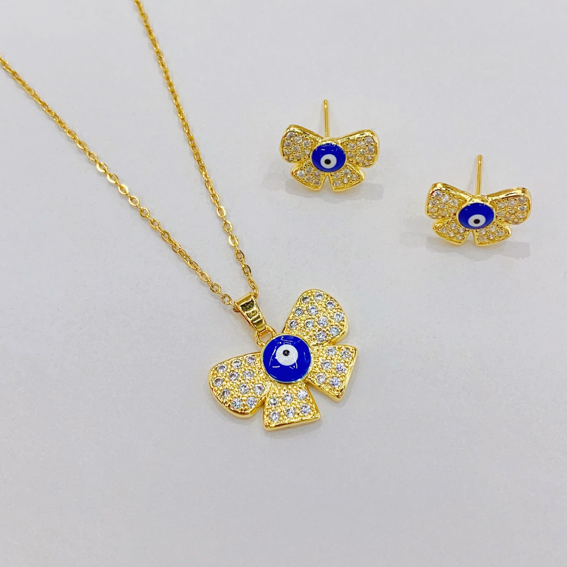 European and American cross-border InS-style Devil's Eye stud necklace set pendant, copper 18K butterfly knot eye necklace earrings details Picture