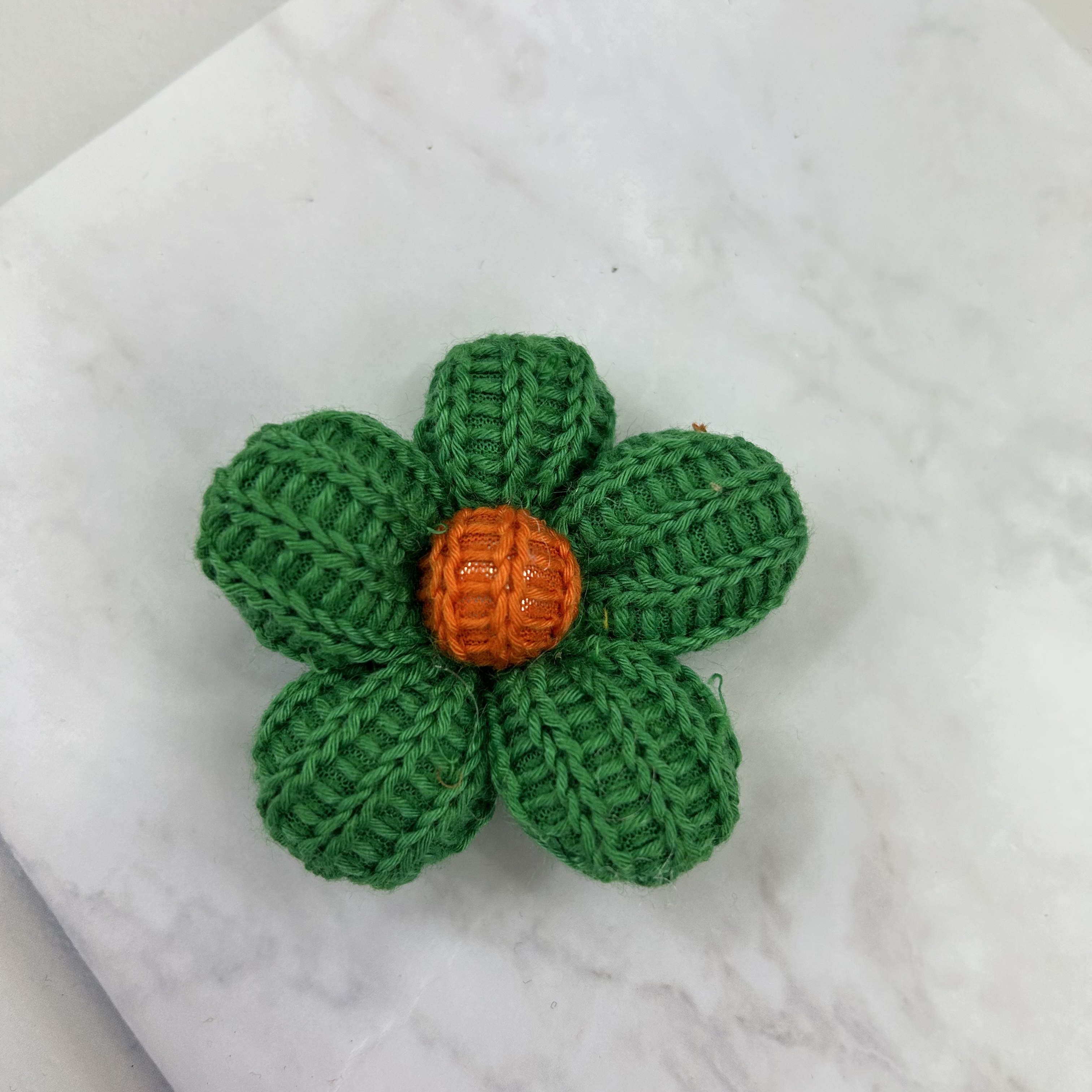 Knitted five-petal flower in different colors