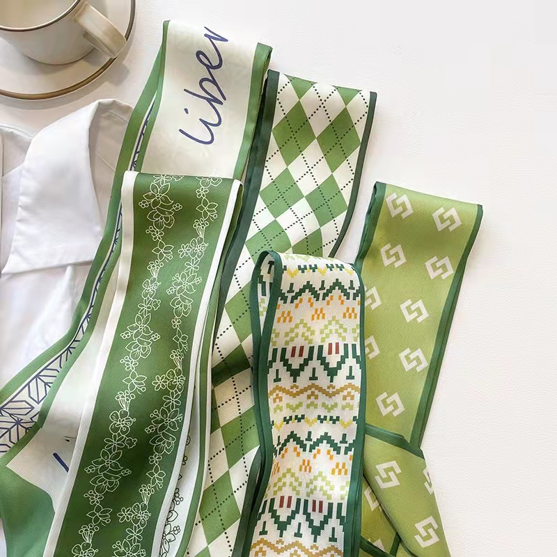 FLY1808 is a green silk scarf that makes women look fair and tender. It features a narrow ribbon-like headband for spring and summer, which can be used to tie hair and bags, as well as a long decorative scarf Item Picture