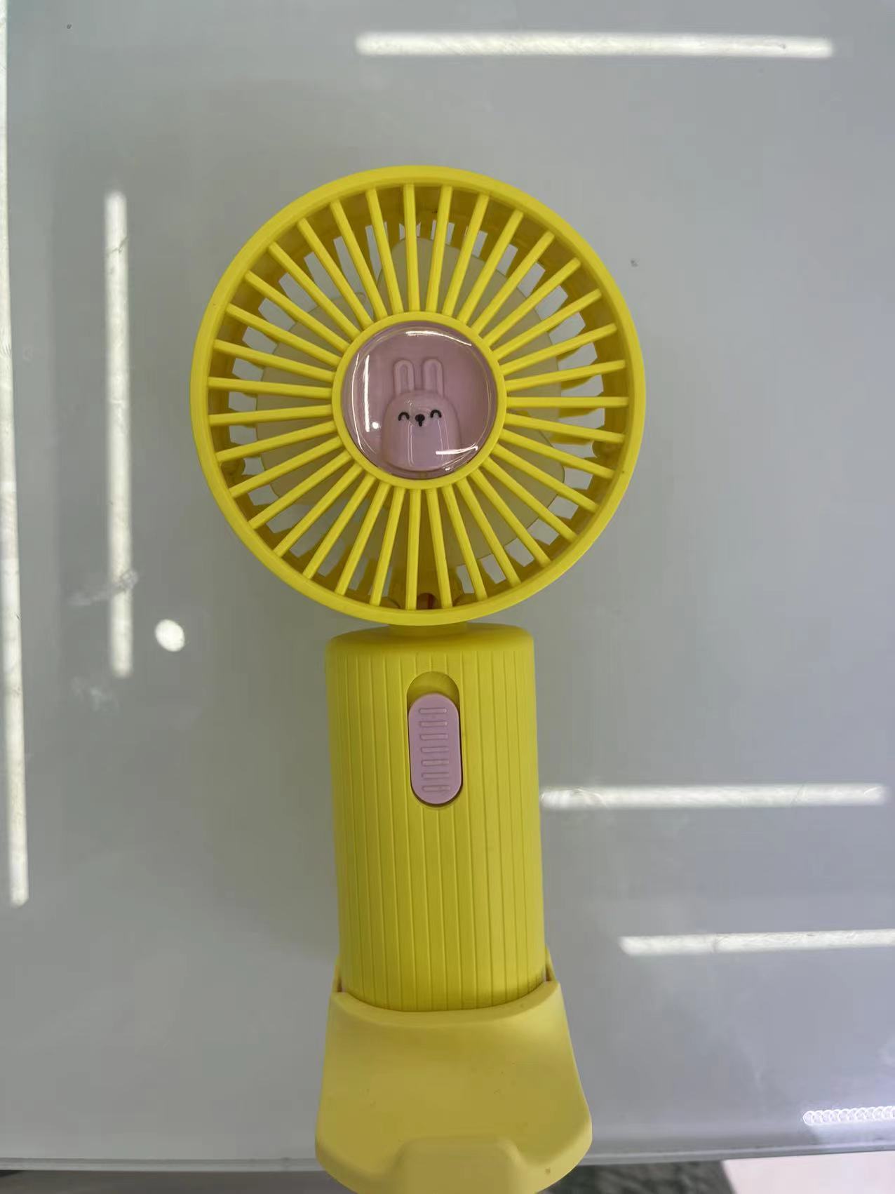 The SQ-326 mini fan has one setting and comes in four colors: purple, blue, pink and yellow. It can be used as a phone stand Application Scenario