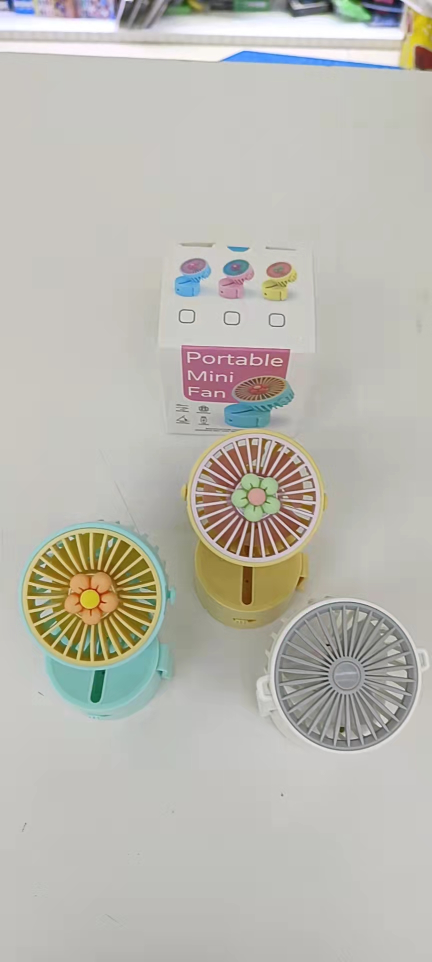 The HQ66-11 flower-shaped neck-hanging fan comes in three colors: yellow, pink and blue. It can be placed on the table with a rope and hung around the neck for easy carrying