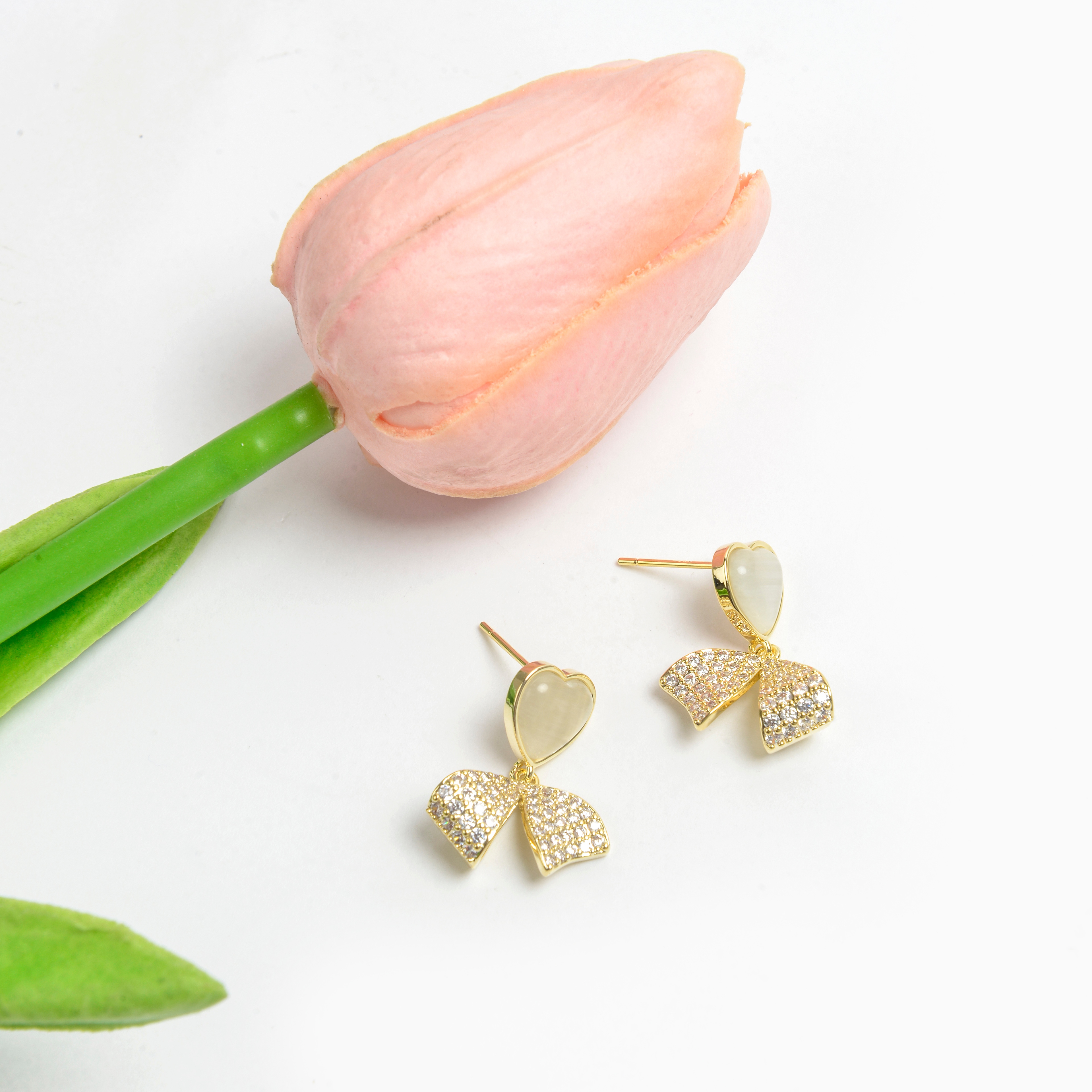 The new earrings feature a niche design with a high-end feel. They are French earrings for women, anti-allergy 925 silver needle, heart-shaped cat's eye stone, bow with diamonds, and fashionable stud earrings