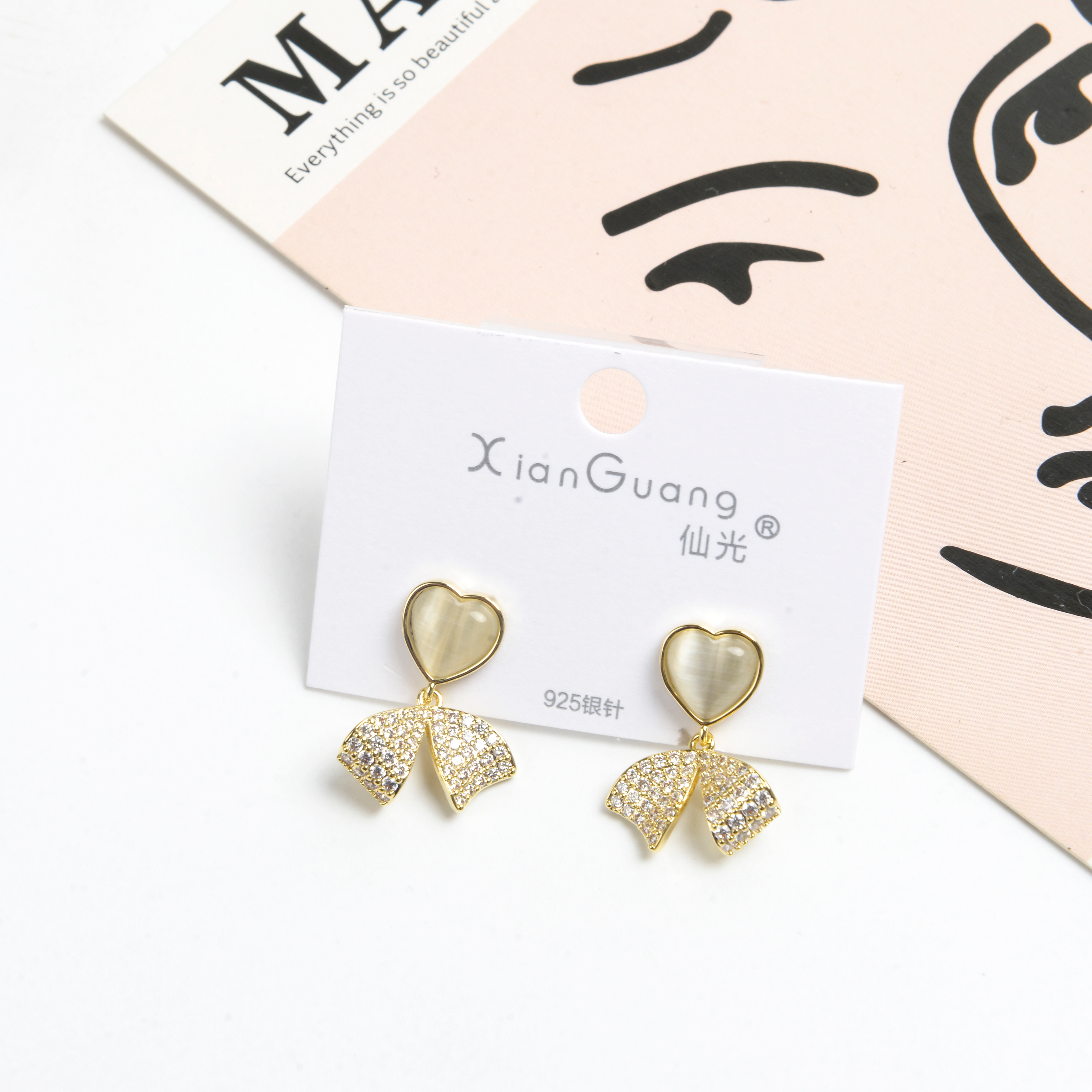 The new earrings feature a niche design with a high-end feel. They are French earrings for women, anti-allergy 925 silver needle, heart-shaped cat's eye stone, bow with diamonds, and fashionable stud earrings details Picture